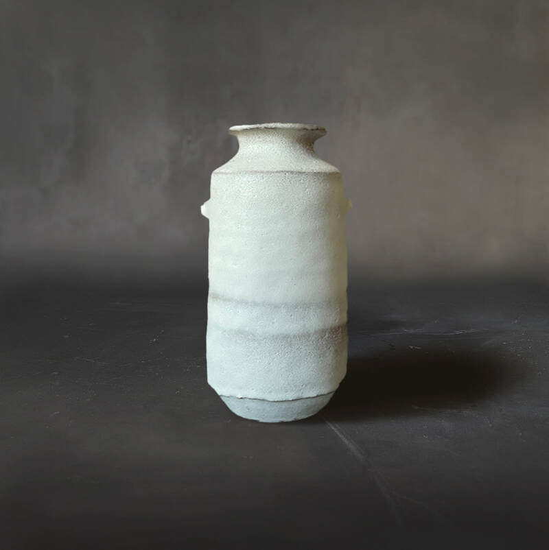 Hand-built buff raku vase with dolomite glaze.