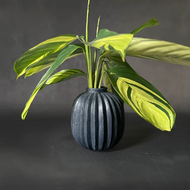 Hand-built and carved pleated raku vase with matt black glaze