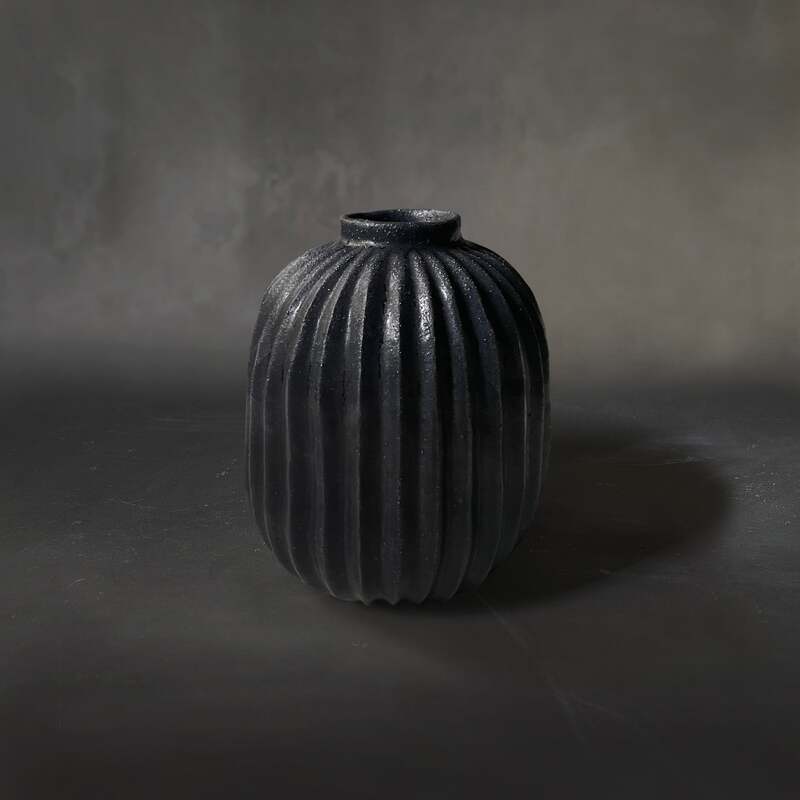 Hand-built and carved pleated raku vase with matt black glaze